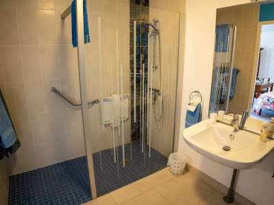 © Façade Chambre et salon Chambre avec frigo Chambre table pour p'tit déj Le lit 160cm et table pour le p'tit déj Salon Salle de douche Douche à l'Italienne Piscine Coin repos près de la piscine Boulodrome